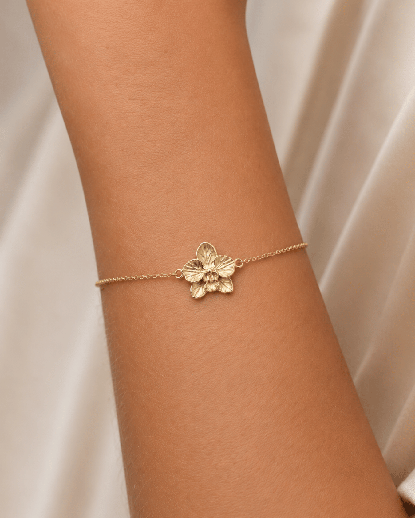 7 Orchid Bracelet – 14K Gold A delicate bracelet handcrafted in solid 14K gold, featuring a beautifully detailed orchid at its center. Inspired by the intricate forms found in nature, each petal is carefully sculpted with fine organic textures, giving the flower a soft, lifelike quality.