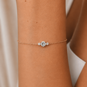 A delicate gold bracelet featuring a luminous aquamarine accented by two sparkling diamonds. Elegant and timeless, designed to add a subtle touch of color and light to the wrist.